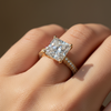 Rose gold ring with a large diamond on a hand against a blurred background
